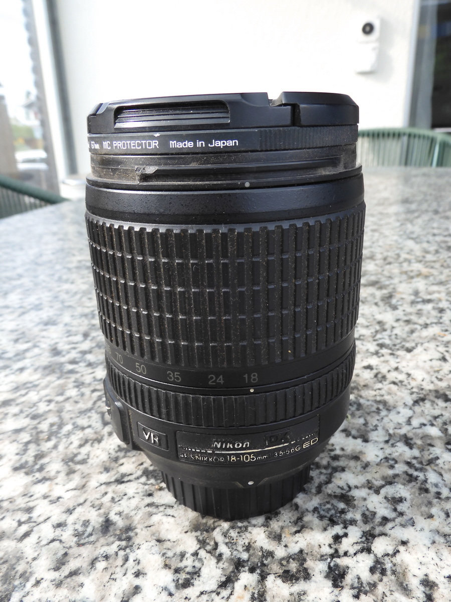 Zoom DX 18 – 105 mm mit Objektivdeckel und Sonnenblende